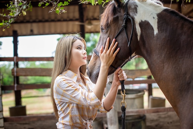 kobieta na stroju w stylu kowbojki na ranczo koni w zachodnim środowisku farmy.