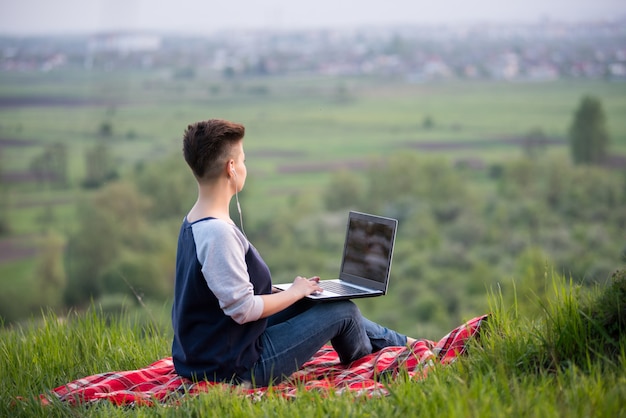 Kobieta na szczycie wzgórza pracuje na laptopie