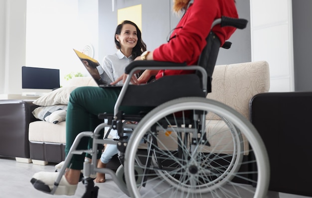 Kobieta na wózku inwalidzkim z laptopem komunikuje się z przyjacielem