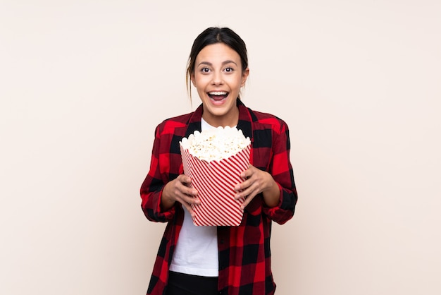 Kobieta nad ścianą trzyma duże wiadro popcorns