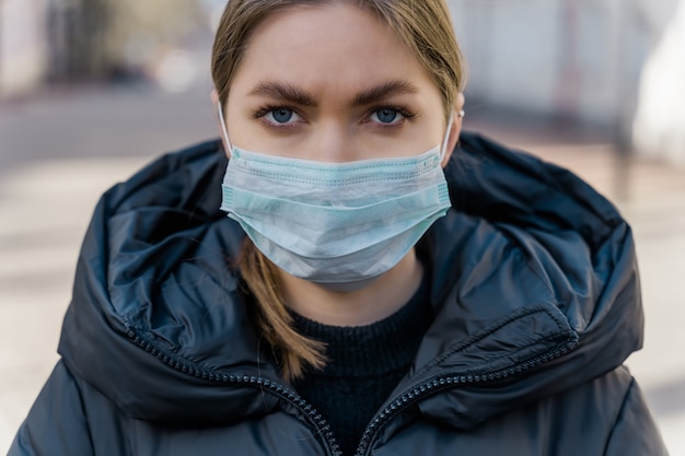 kobieta nałożyła maskę na twarz w celu ochrony przed wirusem covid-19