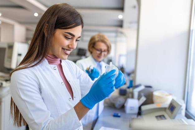 Kobieta Naukowiec Zajmujący Się Badaniami Medycznymi Patrzy Na Próbki Biologiczne Przed Analizą Pod Mikroskopem Cyfrowym W Laboratorium Nauk Stosowanych Inżynier Laboratoryjny W Białym Płaszczu Pracuje Nad Szczepionką I Medycyną