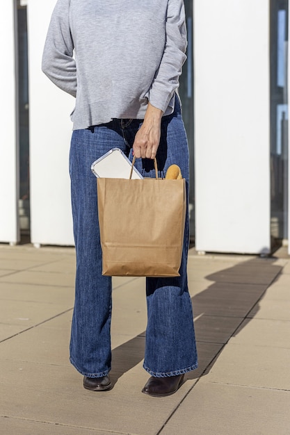 kobieta niosąca papier nadający się do recyklingu zabrać torbę na żywność