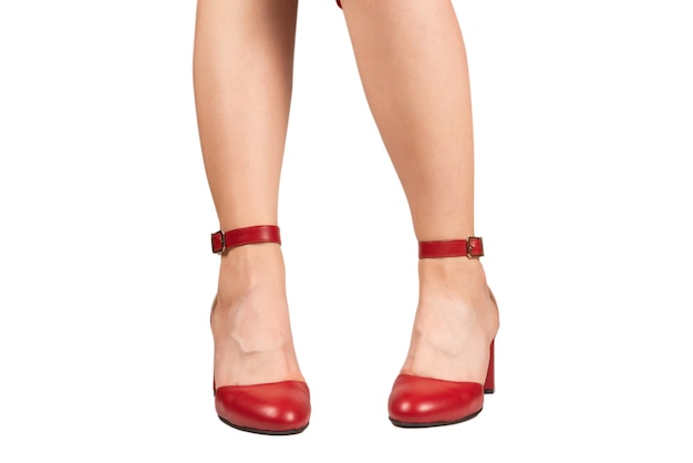 Kobieta nogi w retro czerwone sandały na piętach na białym tle