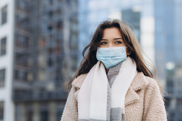 Kobieta noszenie maski ochronne na zewnątrz. Zapobieganie ochronie zdrowia podczas epidemii wirusa grypy, epidemii koronawirusa COVID-19 i chorób zakaźnych w mieście