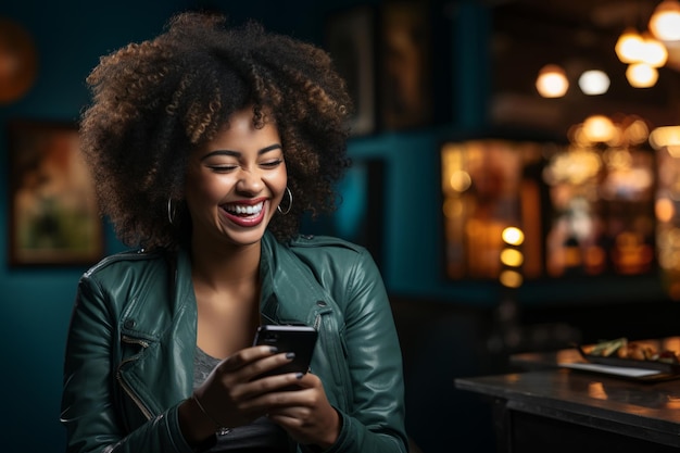 Kobieta o latynoskich rysach, z włosami w stylu afro, patrząca na telefon komórkowy i śmiejąca się w stylu życia w stołówce