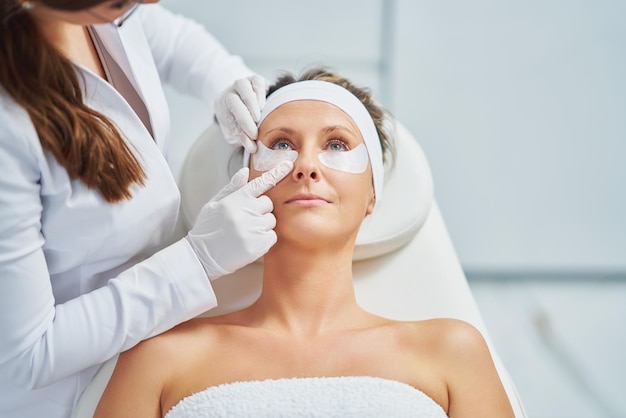 Kobieta o zabiegu kosmetologii brwi w salonie piękności