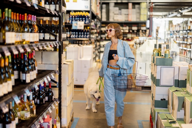 Kobieta odwiedzająca sklep z winami z psem