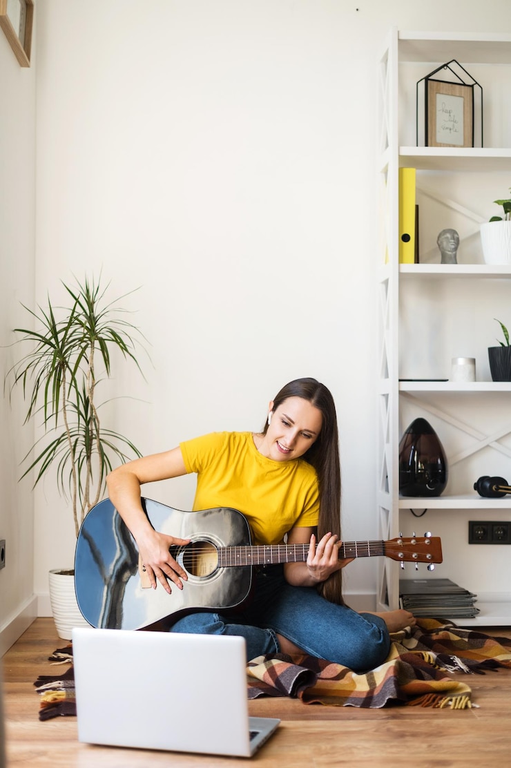 Zdjęcie kobieta ogląda film instruktażowy o grze na gitarze