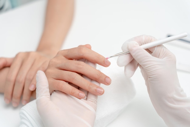 Kobieta otrzymuje opiekę przez profesjonalną kosmetyczkę Manicure w centrum spa Salon kosmetyczny paznokci