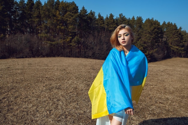 Kobieta owinięta w ukraińską flagę Stoisko z koncepcją Ukrainy