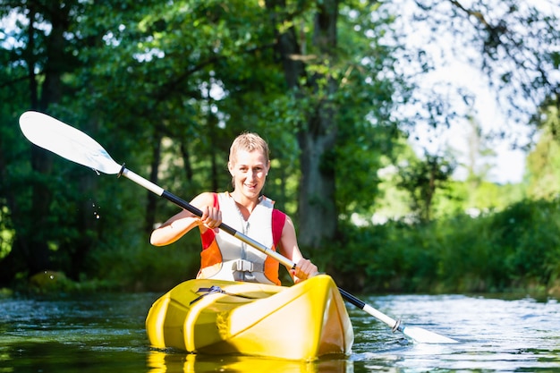 Kobieta paddling z czółnem na lasowej rzece