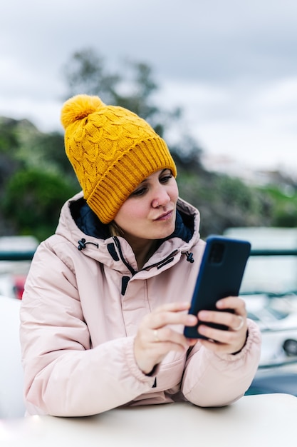 Kobieta patrząc na jej telefon komórkowy gestem pozowania