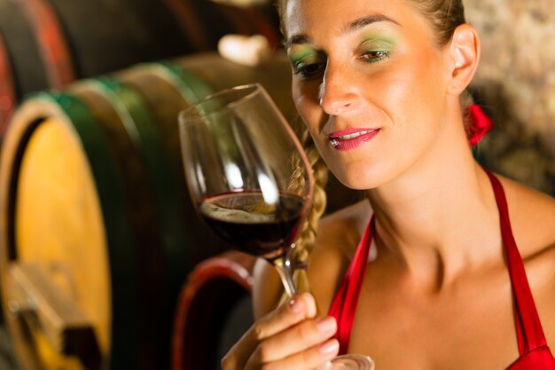 Kobieta patrzeje czerwonego wina szkło w lochu