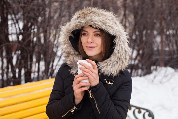 Kobieta pijąca gorący napój z kubka Sezon zimowy