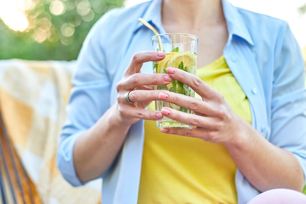 Kobieta pijąca letnią lemoniadę cytrusową z imprezą wielokrotnego użytku metalowych słomek