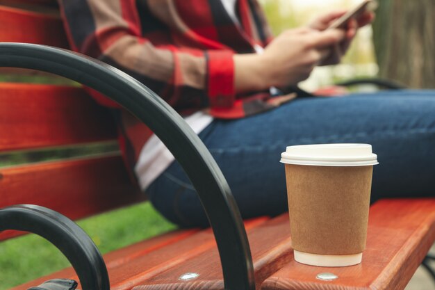 Kobieta Pije Kawę I Używa Smartfona W Parku. Przerwa Na Lunch