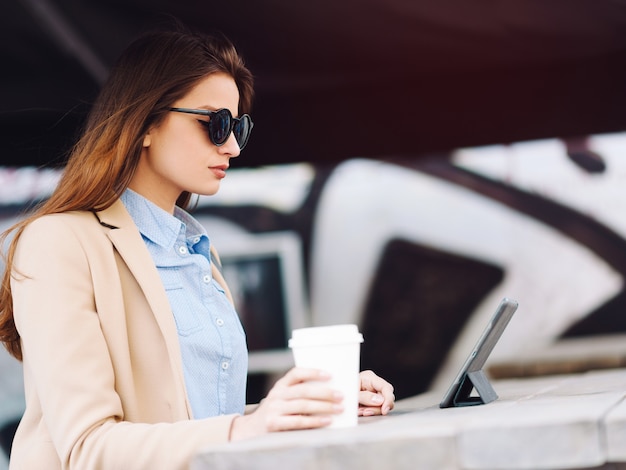 Kobieta Pije Kawę Na Ulicy I Za Pomocą Tabletu