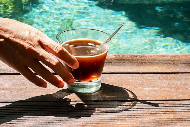 Kobieta pije kawę w basenie Kawa poranna przy basenie