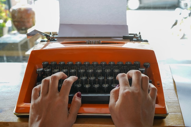 Kobieta pisze na starej maszynie do pisania.
