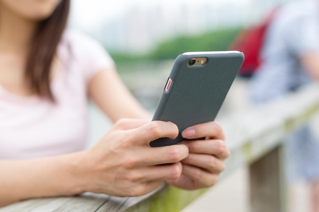 Kobieta pisze SMS-a na swoim telefonie komórkowym