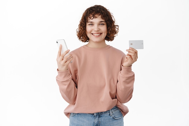 kobieta płacąca online, porządkująca w aplikacji mobilnej, stojąca na białym