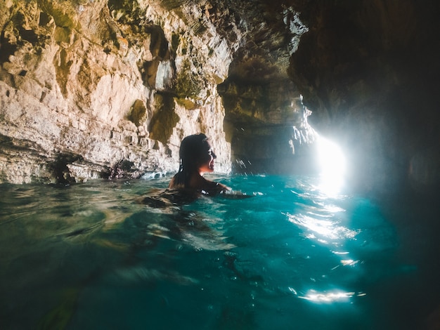 Kobieta pływająca z maską do snorkelingu w grocie morskiej na wakacjach