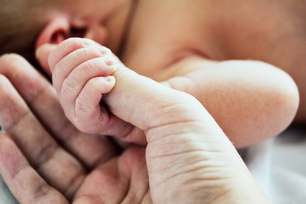 Kobieta po raz pierwszy trzyma rękę swojego nowo narodzonego dziecka
