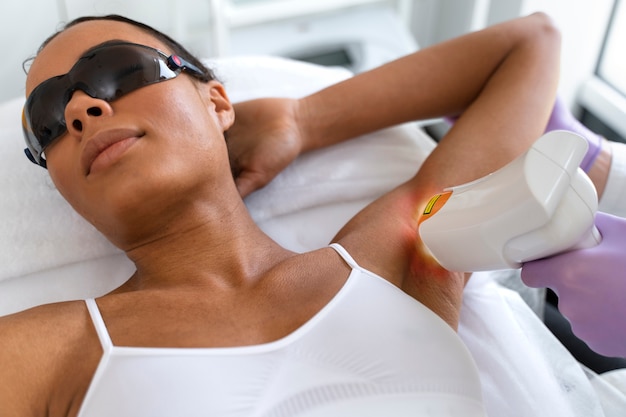 Zdjęcie kobieta pod dużym kątem w klinice depilacji laserowej