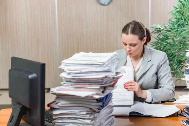 Kobieta pod wpływem stresu wynikającego z nadmiernej pracy na papierze