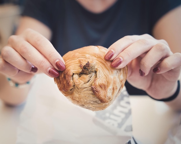 Kobieta podaje tradycyjny, pikantny przysmak do pieczenia ciasta Pastizzi z maltańskiego jedzenia ulicznego