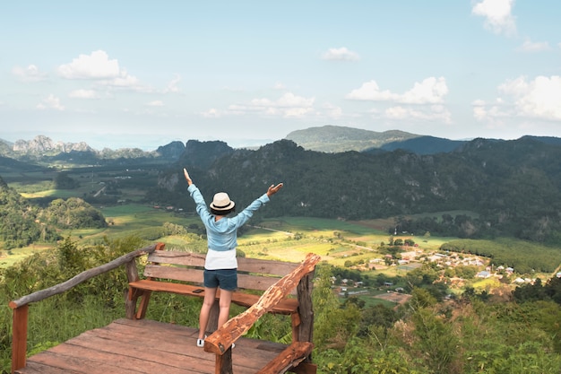 Kobieta podróżnik cieszy się widok i szczęśliwą wolność przy górami. Tajlandia