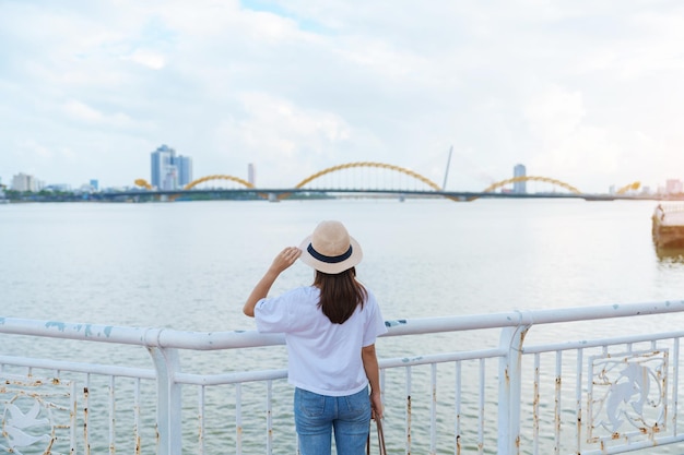Kobieta Podróżnik odwiedzający miasto Da Nang Turysta zwiedzający widok na rzekę z mostem smoka Punkt orientacyjny i popularna atrakcja turystyczna koncepcja podróży do Wietnamu i Azji Południowo-Wschodniej