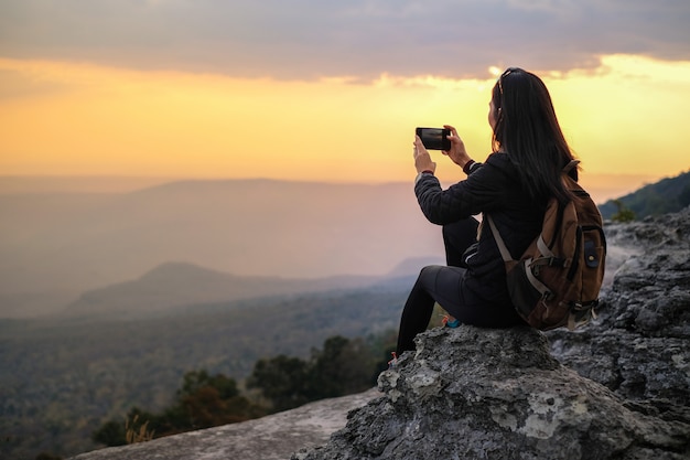 Kobieta podróżnika pozycja na górze góry i brać fotografia widok natura na wakacje.
