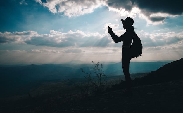 Zdjęcie kobieta podróżnika pozycja na górze góry i brać fotografia widok natura na wakacje.