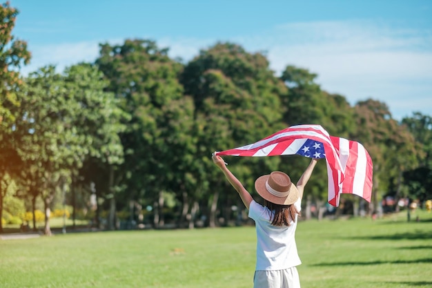 Kobieta podróżująca z flagą Stanów Zjednoczonych Ameryki w parku na świeżym powietrzu USA wakacje Veterans Memorial Independence Fourth of July and Labor Day concept