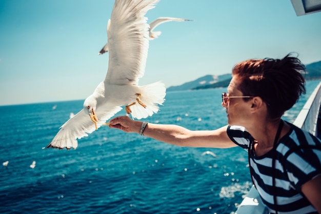 Kobieta podróżuje na ferryboat i karmi seagulls