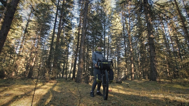 Kobieta Podróżuje Po Mieszanym Terenie Cykloturystyka Z Rowerem Bikepacking Outdoor Podróżnik Podróż Z Torbami Rowerowymi Stylowa Bikepacking Rowerowa Odzież Sportowa W Zielono-czarnej Kolorystyce Magiczny Las Park