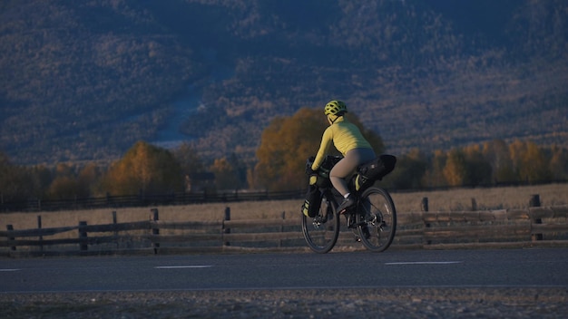 Kobieta Podróżuje Po Terenie Mieszanym Wycieczki Rowerowe Z Bikepackingiem Podróżnik Podróż Z Torbami Rowerowymi Turystyka Sportowa Bikepacking Rower Odzież Sportowa W Kolorach Zielono-czarna Góra śnieg Nakryty