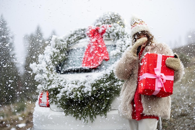 Kobieta podróżuje samochodem z prezentami i wieńcem świątecznym na górskiej drodze