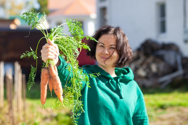 Zdjęcie kobieta pokazuje snop cattot, który wyrósł w jej ogrodzie