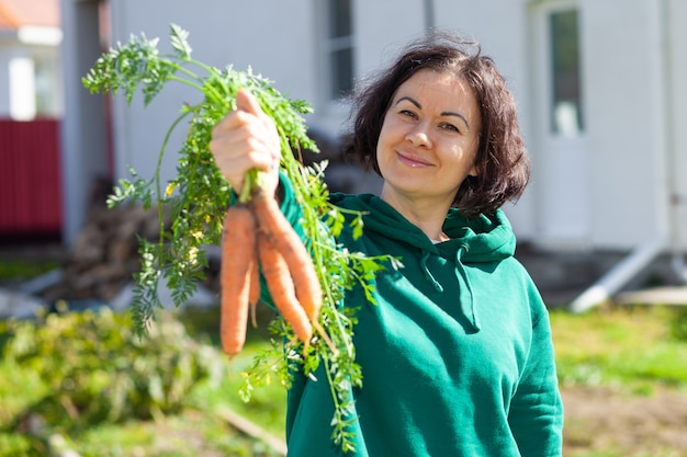Kobieta pokazuje snop cattot, który wyrósł w jej ogrodzie