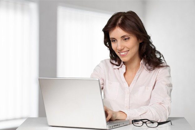 Kobieta pozuje w pobliżu laptopa