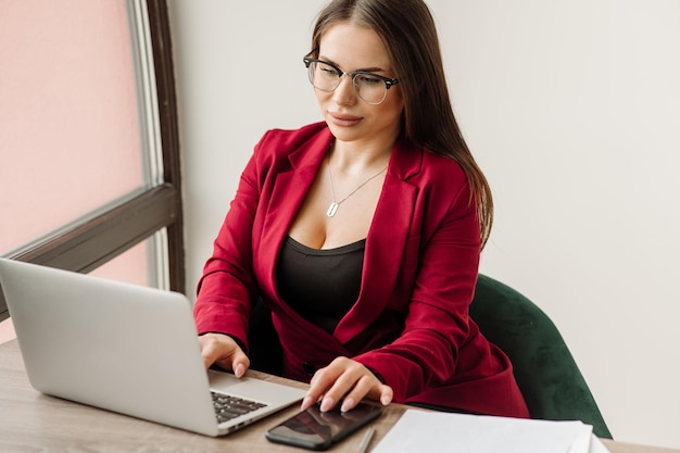 Kobieta pracownik biurowy lub sekretarka pracuje z laptopem na biurku Portret seksownego pracownika biurowego