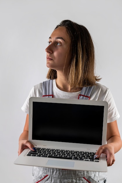 Kobieta pracownik budowlany trzyma laptopa w ręce Pojedynczo na białym tle