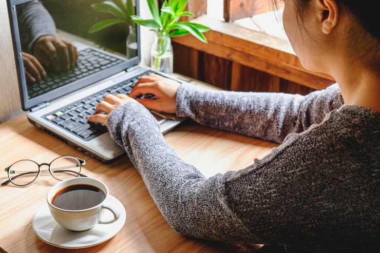 Zdjęcie kobieta pracująca na laptopie obok okna w domu