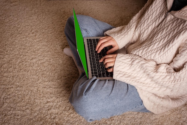 Zdjęcie kobieta pracująca na laptopie znajdująca inspirację na podłodze w salonie przypadkowa kreatywność