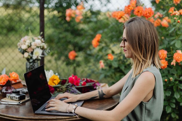 Kobieta pracująca na swoim laptopie w ogrodzie