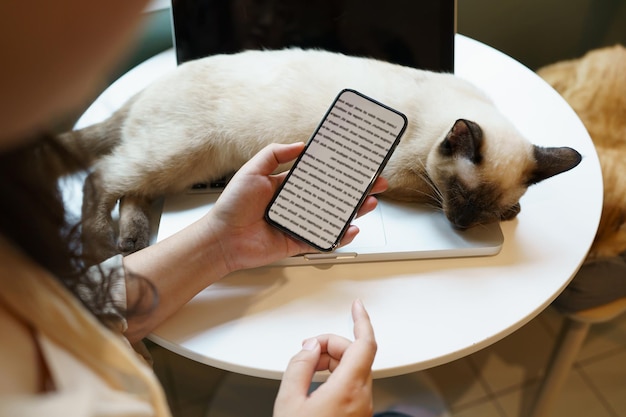 Kobieta pracująca na telefonie z domu z kotem Kot śpiący na laptopie Asystent klawiatury Kot pracujący na laptopie