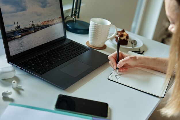 Kobieta pracująca w domowym biurze korzysta z laptopa